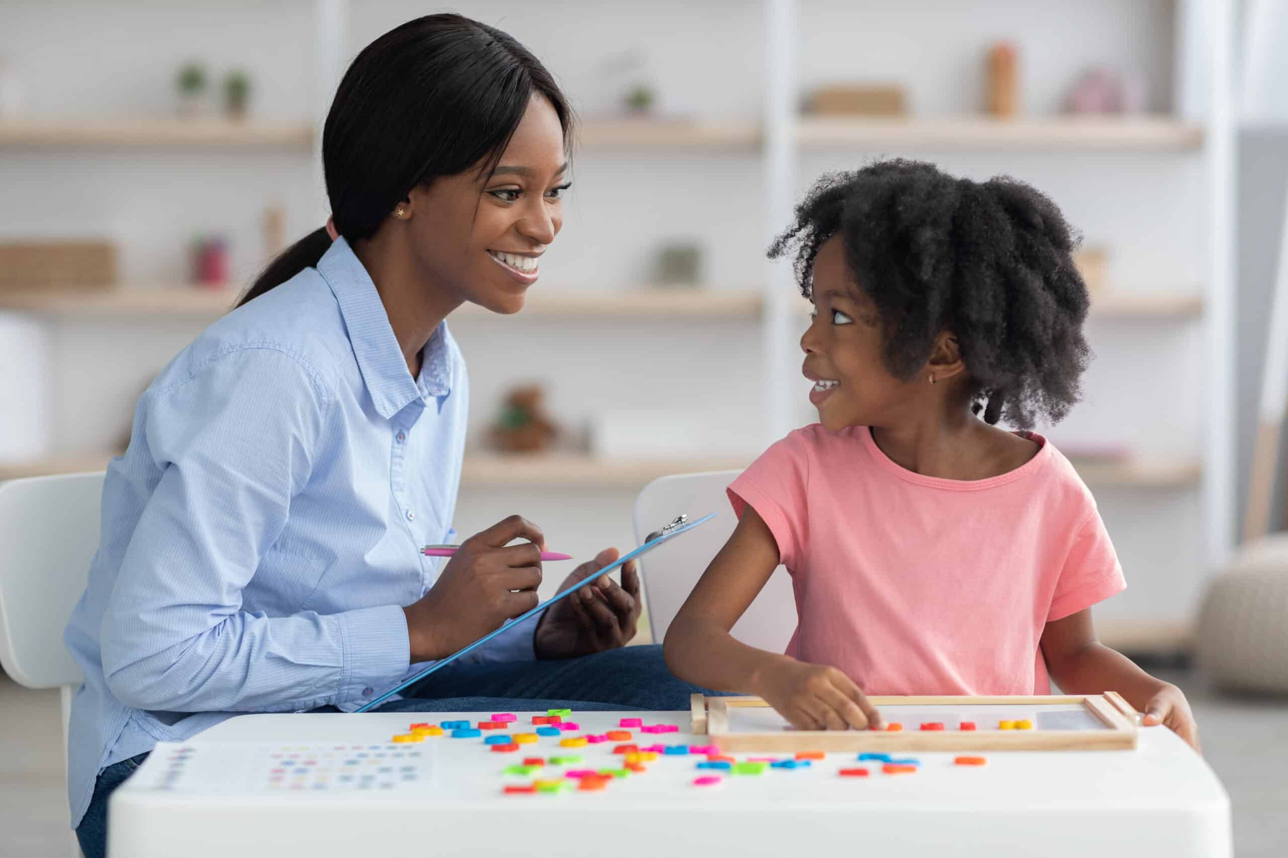 Cheerful child development specialist testing cute little girl Cheerful child development specialist testing cute little girl